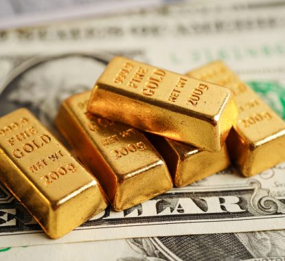 Gold bars on US dollar banknote money, finance trading investment business currency concept.